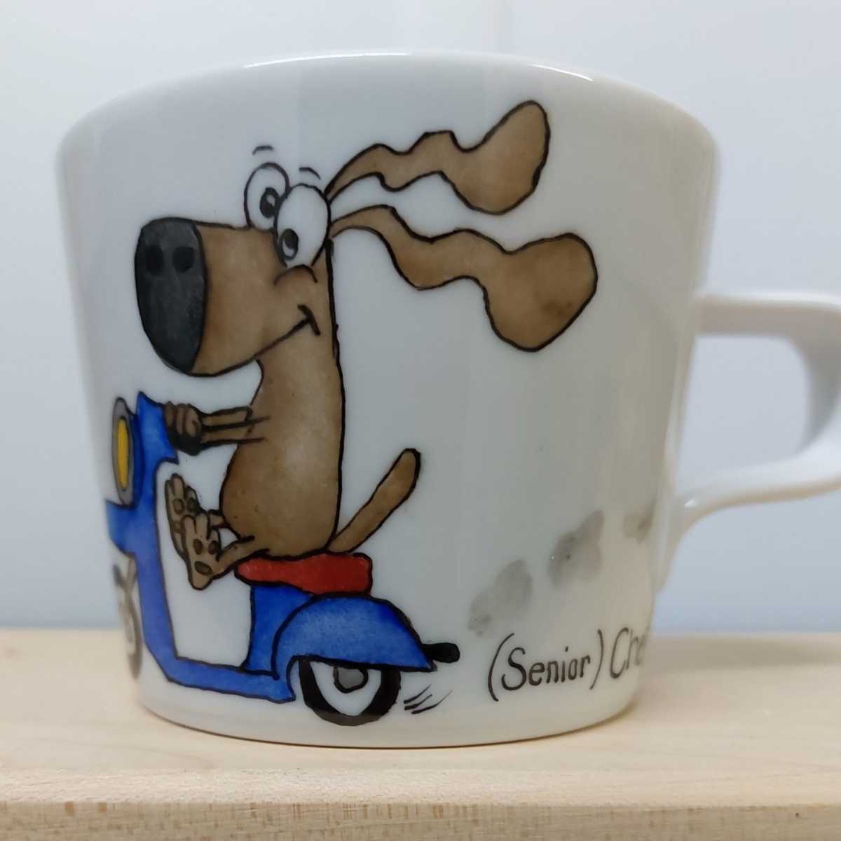 Tasse mit Hund auf einem Roller.