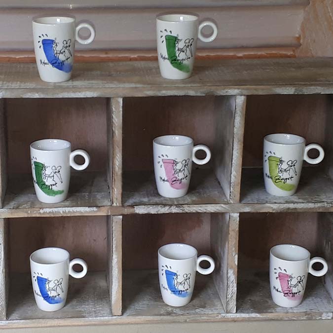 Regal mit handbemalten Espresso-Tassen als Werbegeschenke